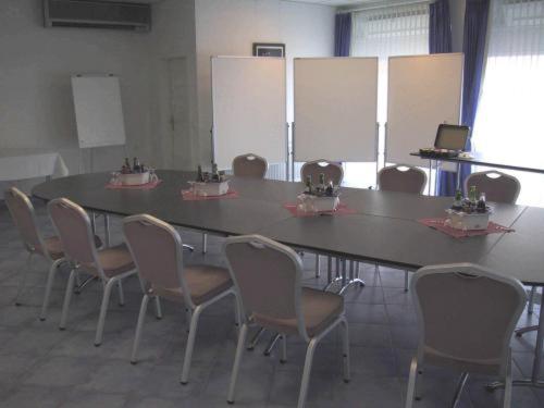 einen Konferenzraum mit einem großen Tisch und Stühlen in der Unterkunft Hotel-Restaurant Zum Goldenen Löwen in Kelkheim