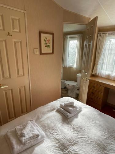 a bedroom with two towels on a bed at Happy Days Holiday Home Whithorn2 in Newton Stewart