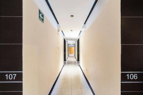 a corridor in a building with black tiles at Hotel Kapu, Puebla in Puebla