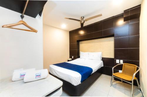 a hotel room with a bed and a chair at Hotel Kapu, Puebla in Puebla