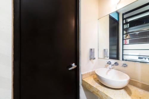 a bathroom with a sink and a mirror at Hotel Kapu, Puebla in Puebla