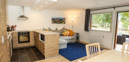 un petit salon avec un canapé et une cuisine dans l'établissement Chalet Grand Balcon, aux Houches