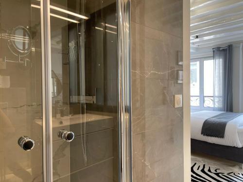 - une douche avec une porte en verre dans la chambre dans l'établissement Studio Beaubourg Marais, à Paris