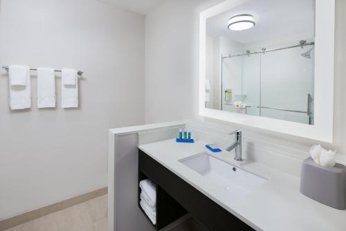 a white bathroom with a sink and a mirror at Holiday Inn Express & Suites- Sugar Land SE - Missouri City by IHG in Missouri City