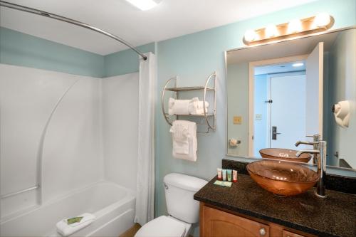 a bathroom with a sink and a toilet and a tub at Palette Resort Myrtle Beach in Myrtle Beach