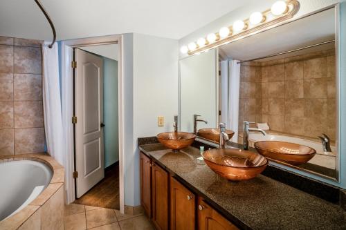 uma casa de banho com 3 lavatórios e um espelho grande em Palette Resort Myrtle Beach by OYO em Myrtle Beach