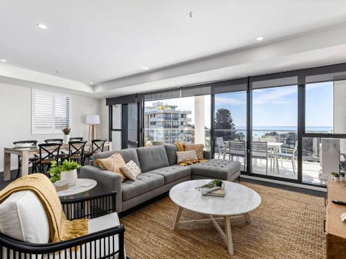 a living room with a couch and tables at Cove 603 in Forster
