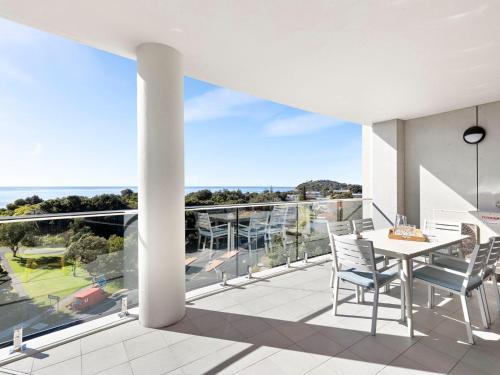 a patio with a table and chairs on a balcony at Cove 603 in Forster