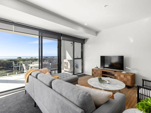 a living room with a couch and a tv at Cove 603 in Forster