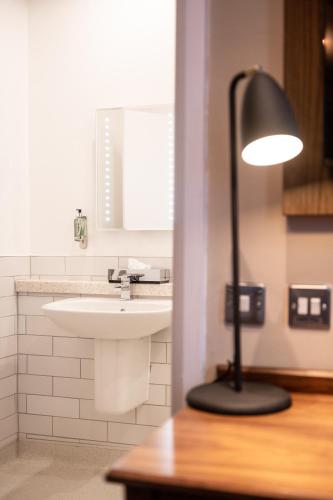 a black lamp sitting next to a sink in a bathroom at Miller & Carter Brighton by Innkeeper's Collection in Brighton & Hove
