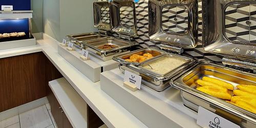 a buffet with trays of food on a counter at Holiday Inn Express & Suites - Manitou Springs, an IHG Hotel in Manitou Springs