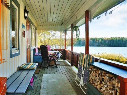 une terrasse couverte d'une maison avec un banc et une table dans l'établissement 2 person holiday home in BENGTSFORS, à Bengtsfors