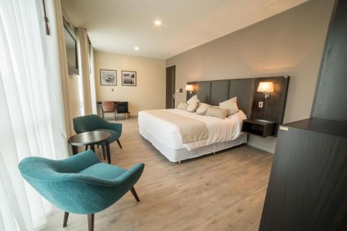 a hotel room with a bed and a table and chairs at Huper Hotel Boutique in Cochabamba