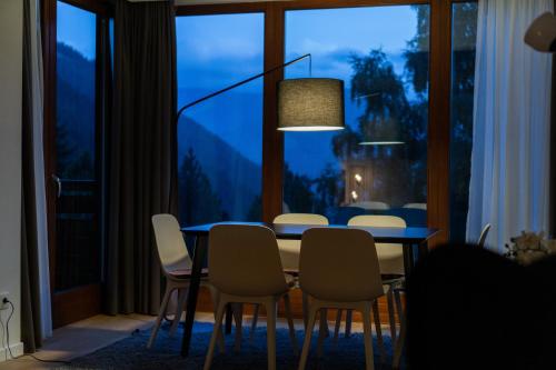 ein Esszimmer mit einem Tisch, Stühlen und einem Fenster in der Unterkunft Sunshine @ Rosie Design Chalet in Bad Kleinkirchheim
