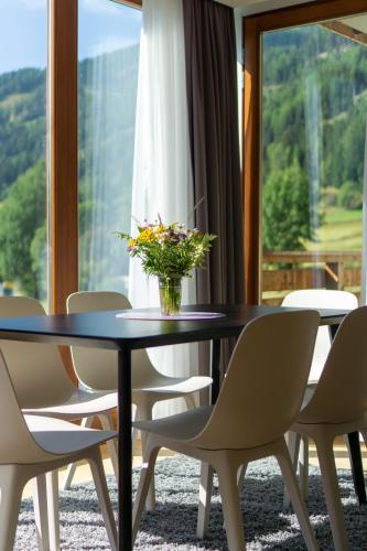 a table with chairs and a vase of flowers on it at Sunshine @ Rosie Design Chalet in Bad Kleinkirchheim