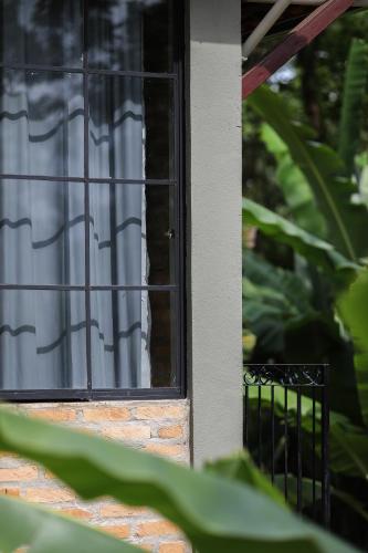 a window of a house with a white curtain at Charmoso studio em Tiradentes in Tiradentes