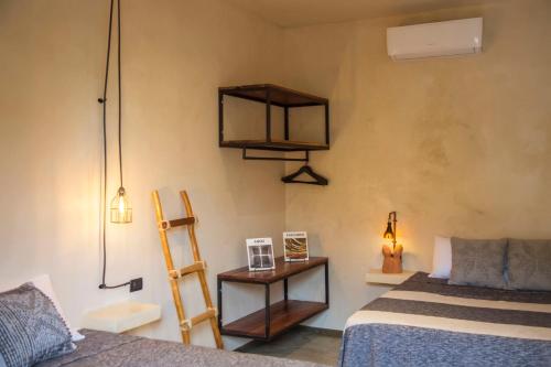 a bedroom with a bed and a ladder and shelves at Bot&aring;nica Tulum in Tulum
