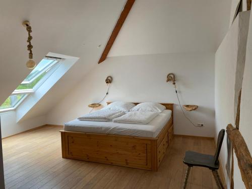 a bedroom with a bed in a attic with a window at Sonnenschein am Rursee in Simmerath