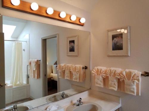 a bathroom with two sinks and a large mirror at Schooner Landing in Newport