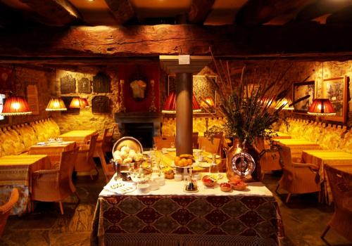 un comedor con mesas y sillas y una mesa con comida en Hotel Almud en Sallent de Gállego