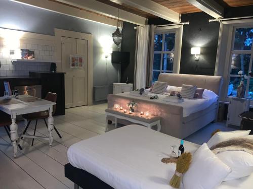 ein Wohnzimmer mit zwei Betten und einem Tisch mit Lampen in der Unterkunft Wellness Sauna Beauty Farm Midwolda in Midwolda