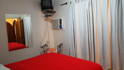 1 dormitorio con cama roja y espejo en Peatonal y San Martin en Mendoza