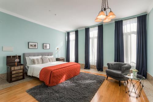 a large bedroom with a bed and a chair at Carpe Diem Apartments in Porto