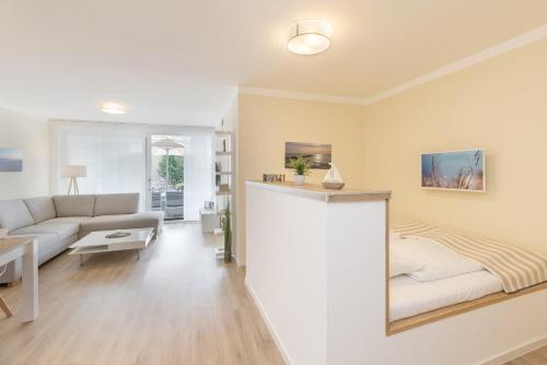 een woonkamer met een bed en een bank bij Wicheldorfstraße 20 Wohnung 109 in Grömitz