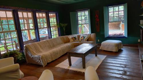 a living room with a couch and a table at Casa Verde-Casa de Temporada no Bichinho in Bichinho