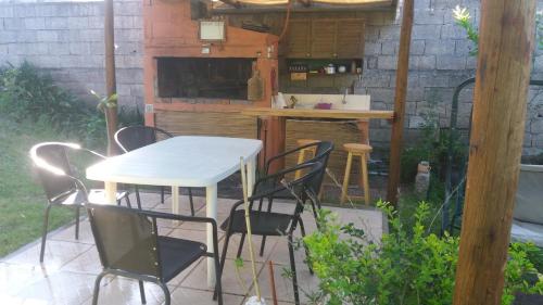 un patio con mesa y sillas en un patio trasero en Apartamentos del Este en Piriápolis