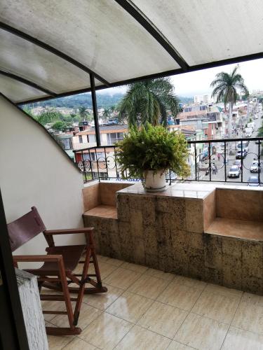 a balcony with a chair and a plant at HOTEL COSTA DEL SOL FUSAGASUGa in Fusagasuga