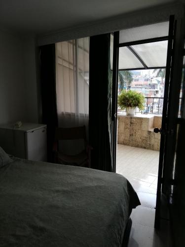 a bedroom with a bed and a sliding glass door at HOTEL COSTA DEL SOL FUSAGASUGa in Fusagasuga