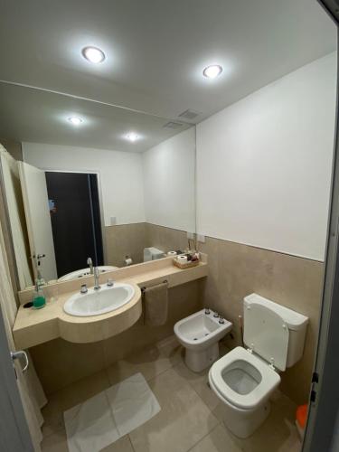 a bathroom with a sink and a toilet and a mirror at Departamento Studio in Corrientes