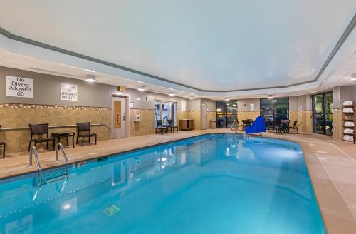 a pool in a hotel with chairs and tables at Holiday Inn Express Hotel & Suites Mount Juliet - Nashville Area by IHG in Mount Juliet