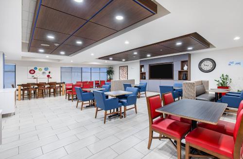 a dining room with tables and chairs and a tv at Holiday Inn Express Hotel & Suites Mount Juliet - Nashville Area by IHG in Mount Juliet