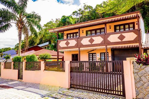 uma casa com uma cerca em frente em Pousada Casa do Oscar em Governador Celso Ramos