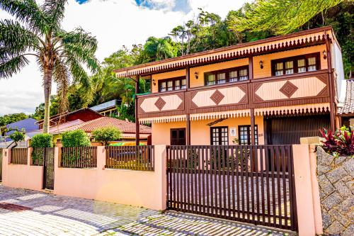 a house with a fence in front of it at Pousada Casa do Oscar in Governador Celso Ramos