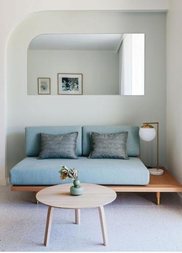a living room with a blue couch and a table at The Surf Yamba in Yamba
