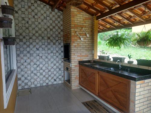 a kitchen with a sink and a brick wall at Recanto Guadalupe in Chã Grande