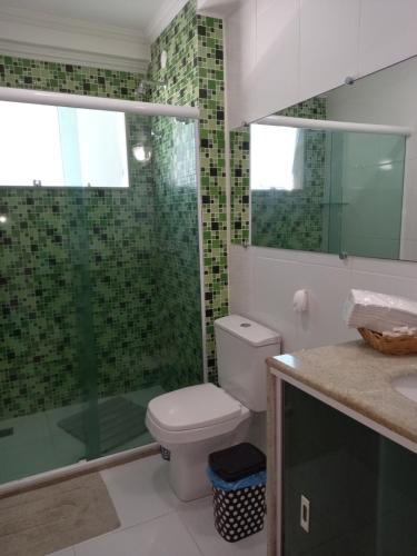 a bathroom with a toilet and a glass shower at Apto de 2 quartos vista pro mar de Itaúna in Saquarema