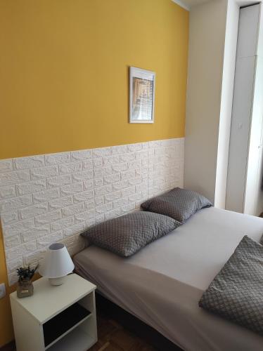 um quarto com uma cama com uma parede amarela em apartman Liman em Novi Sad