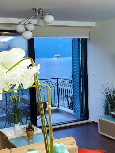a room with a balcony with a view of the ocean at Apartment FUNNY in Kotor