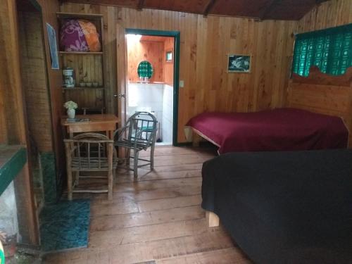 a room with two beds and a table and chairs at Las Cataratas Lodge in San Gerardo de Dota