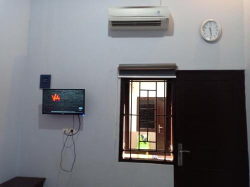 a room with a window and a clock on the wall at Homestay dan Kost 78 in Jepara