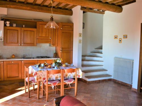 kuchnia ze stołem z krzesłami i schodami w obiekcie Holiday Apartment Close to Asciano w mieście Asciano