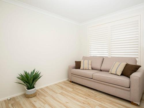 a living room with a couch and a window at Havenwood - Pet Friendly - Spa & Community Pool in Callala Beach