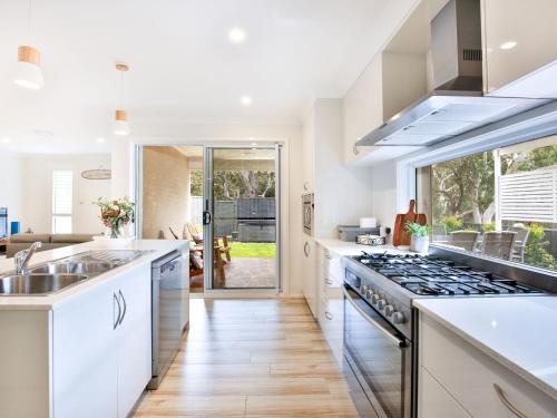 a kitchen with white counters and a stove top oven at Havenwood - Pet Friendly - Spa & Community Pool in Callala Beach