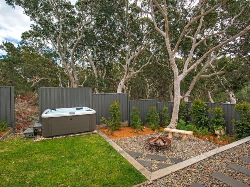 a backyard with a hot tub in the grass at Havenwood - Pet Friendly - Spa & Community Pool in Callala Beach