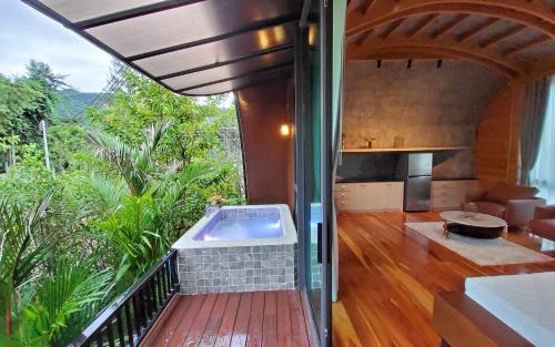 a house with a hot tub on a balcony at The Hidden Village, Khao Yai in Mu Si