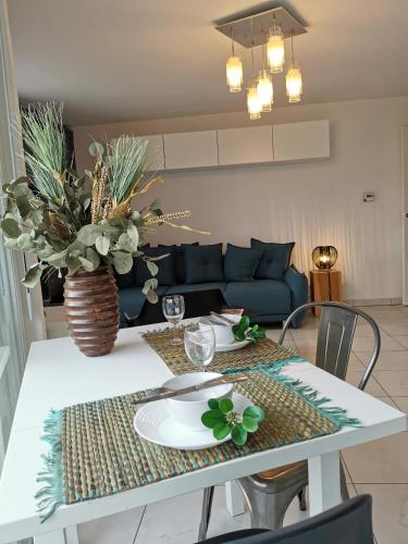 - une table à manger avec un canapé bleu dans le salon dans l'établissement CÔTÉ GARE - Gare - Centre-ville - Parking - Netflix - Wifi - Disney+ - Terrasse, à Annecy